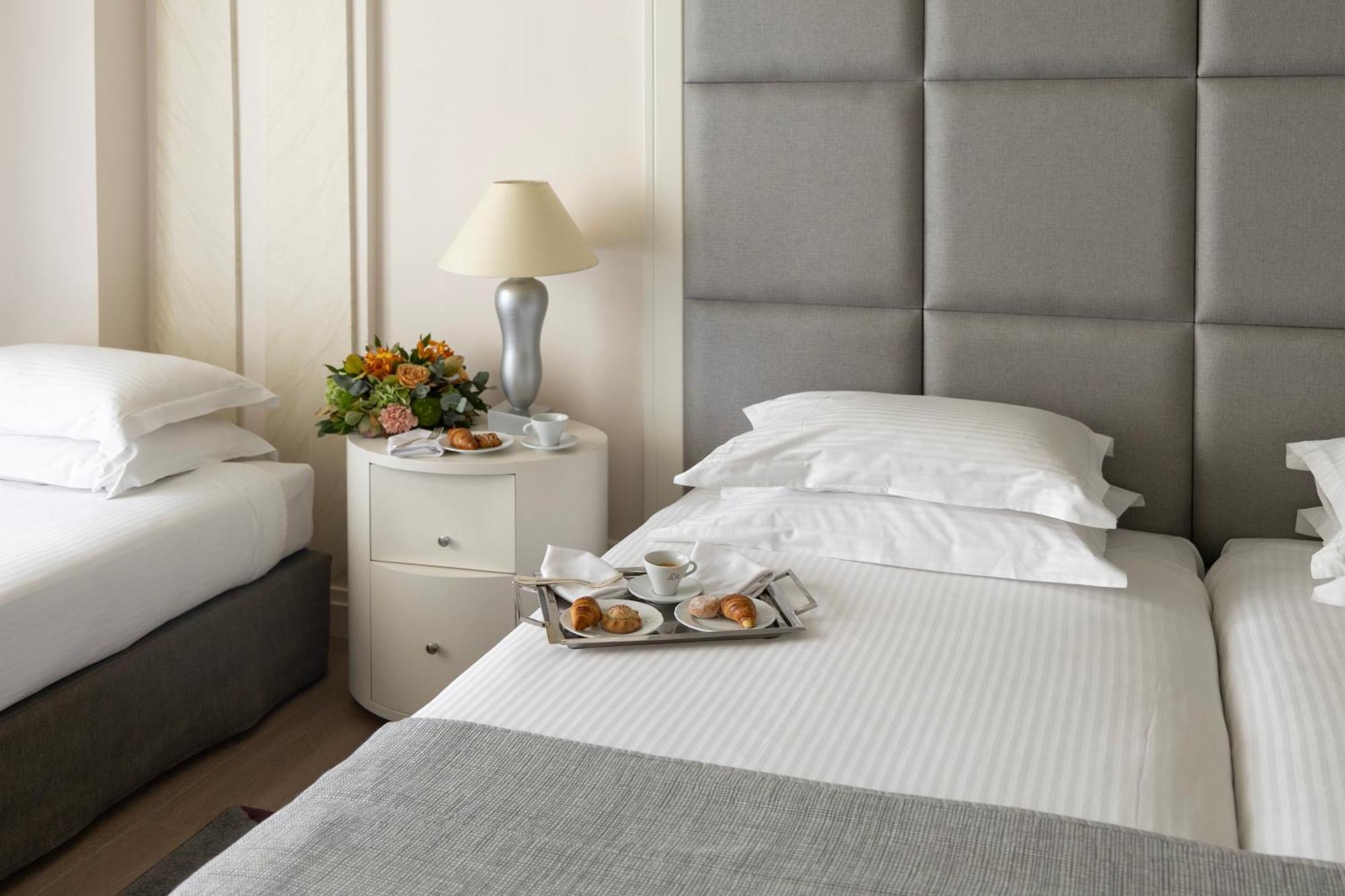 Njv Athens Plaza Hotel Ngoại thất bức ảnh A bed with a nightstand